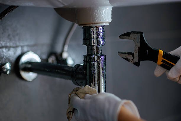 Profix engineer repairing pipework under a sink